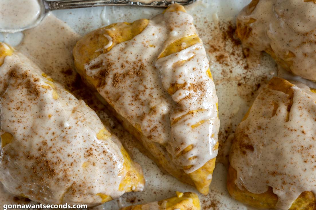 pumpkin spice scones with double glaze on a baking sheet