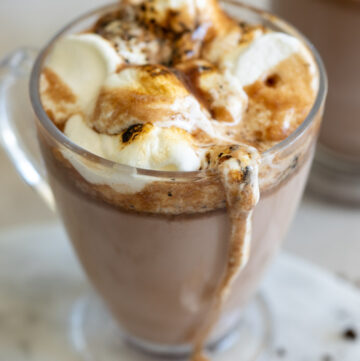 A cup of crockpot hot chocolate topped with toasted marshmallow