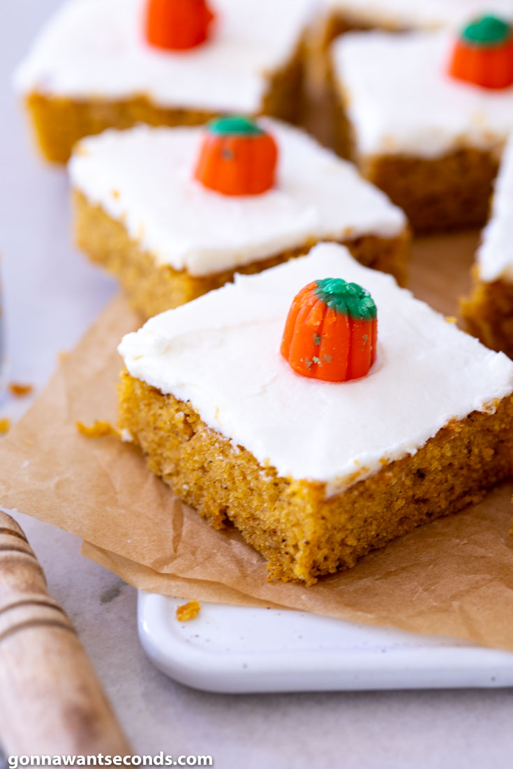 Slices of Pumpkin Bars with Cream Cheese Frosting, decorated with candy pumpkin