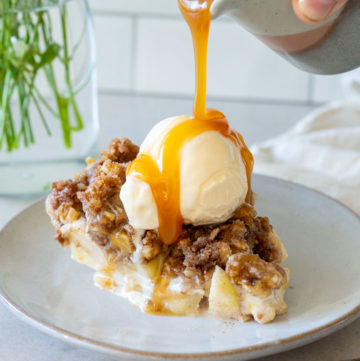 Caramel drizzles over a slice of Sour Cream Apple Pie topped with ice cream