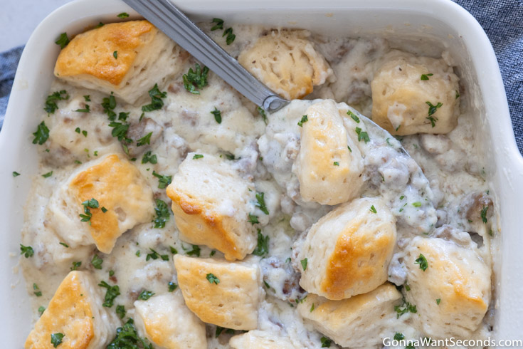 serving spoon in biscuit casserole with gravy