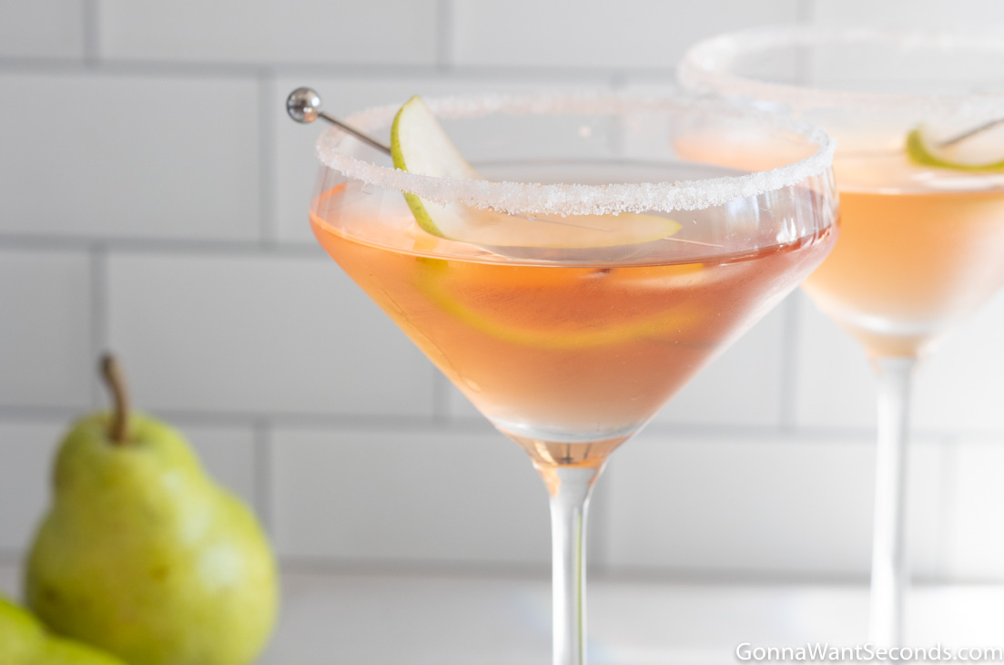 a glass of pear vodka martini, garnished with a slice of pear