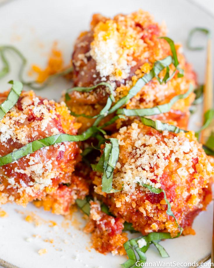 These tender and juicy chicken parmesan meatballs elevate a simple chicken dinner to something absolutely wonderful. Add this to your dinner rotation! #chickenmeatballs #meatballs chicken parmesan meatballs on a plate with garnish on top