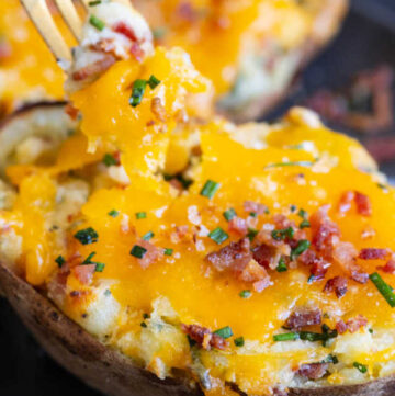 These twice baked potatoes are the perfect side dish. An oven-baked potato shell stuffed with mashed potatoes that are loaded with cheese, sour cream, chives, and bacon. #bakedpotatoes #sidedishes #potatosidedishes
