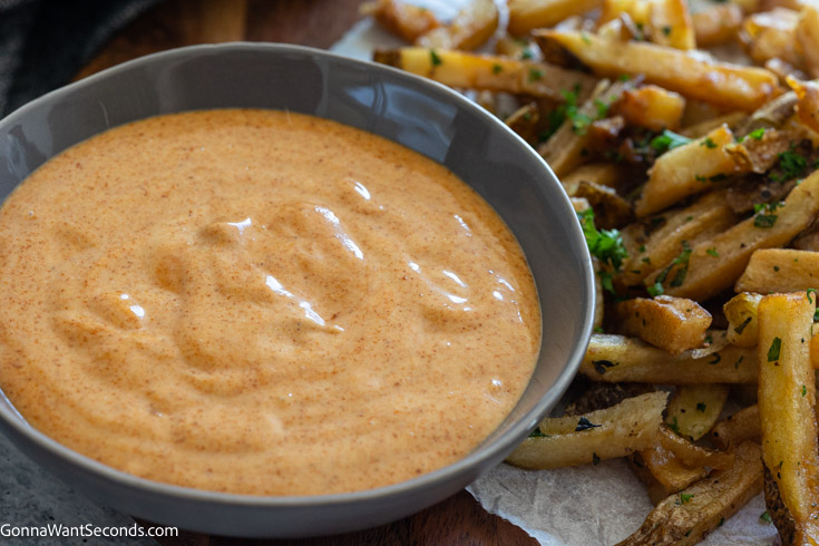 Awesome sauce in a shallow bowl with french fries on the side