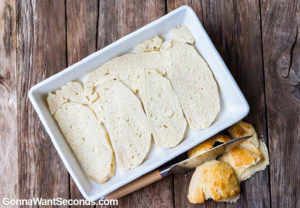 Slices of bread arranged in a single layer, in a baking dish