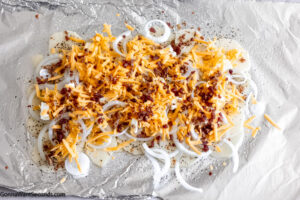 how make campfire cheesy potatoes, placing all the ingredients on aluminum foil
