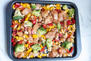 How to make cashew chicken sheet pan, mix sauce, chicken and veggies
