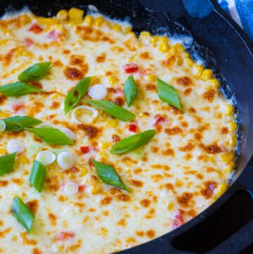 Korean cheese corn topped with green onions, in a cast iron skillet
