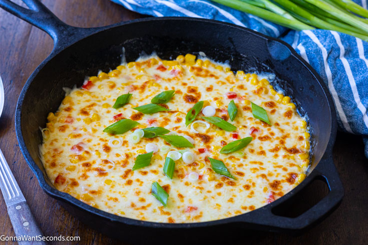 Korean corn topped with green onions, in a cast iron skillet