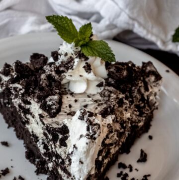A slice of Oreo Pie garnished with mint leaves on plate