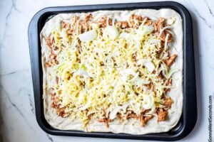 How to make sheet pan BBQ chicken pizza , sprinkling cheese again
