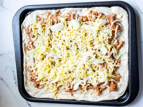 How to make sheet pan BBQ chicken pizza , sprinkling cheese again