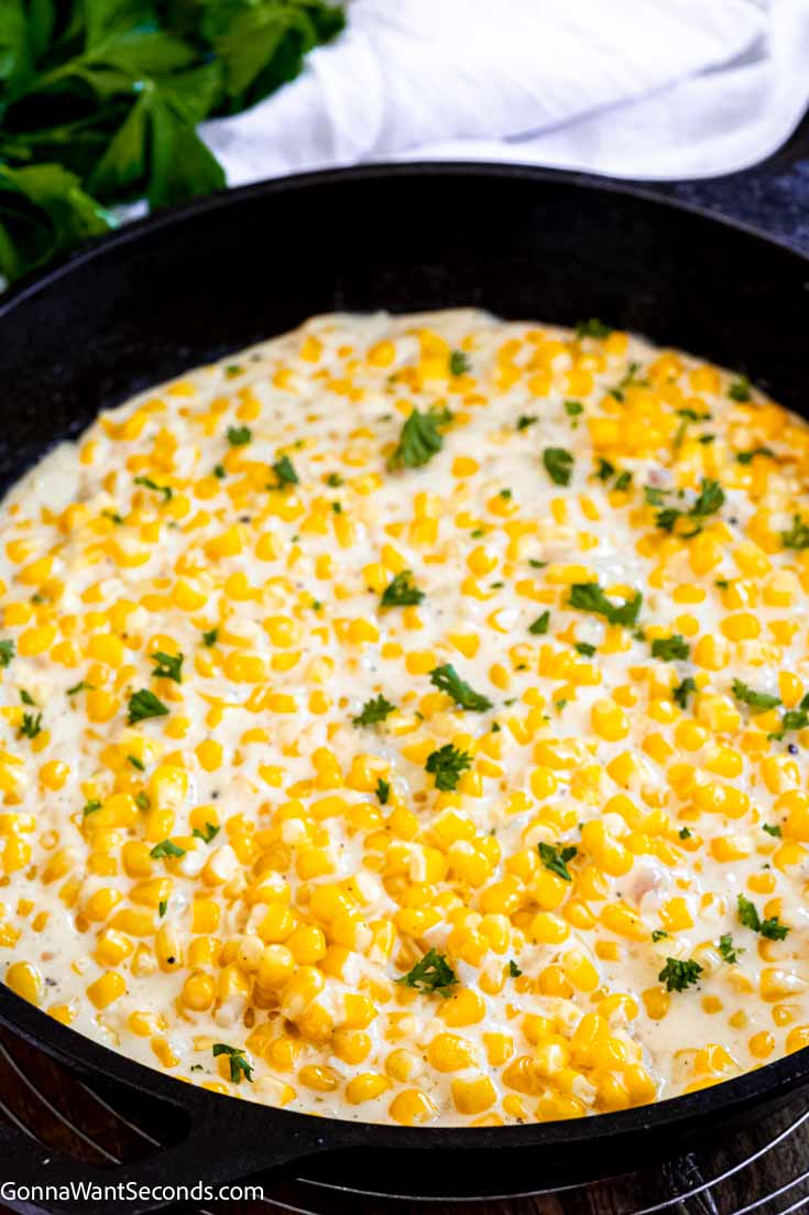 Our honey butter skillet corn is a sweet and savory side dish that's easy to make and your family will ask for on repeat!!! #buttercorn #skilletcorn honey butter skillet corn with cream cheese in a cast iron skillet