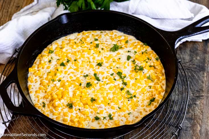 Our honey butter skillet corn is a sweet and savory side dish that's easy to make and your family will ask for on repeat!!! #buttercorn #skilletcorn honey butter creamy skillet corn in a cast iron skillet