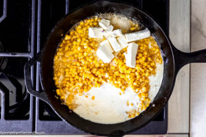 Step 4 how to make honey butter creamy skillet corn, Stir in the heavy cream and cubed cream cheese. Simmer.