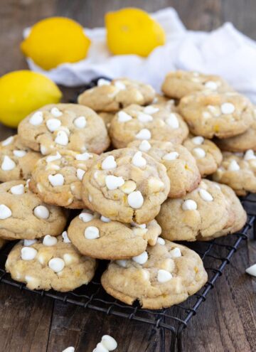 a pile of lemon white chocolate chip cookies on a cooling rack