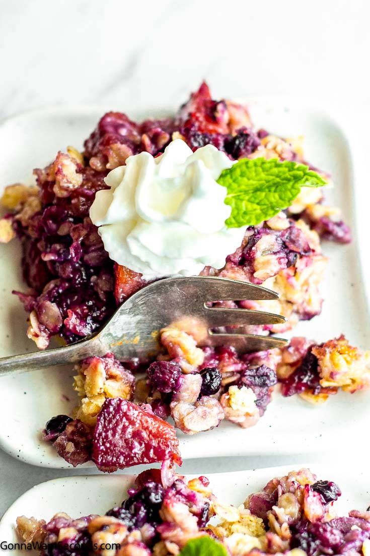 peach blueberry cobbler on a square plate, with fork