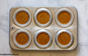How to make pumpkin spice pie cupcakes , pouring the cupcake mixture in the muffin tins