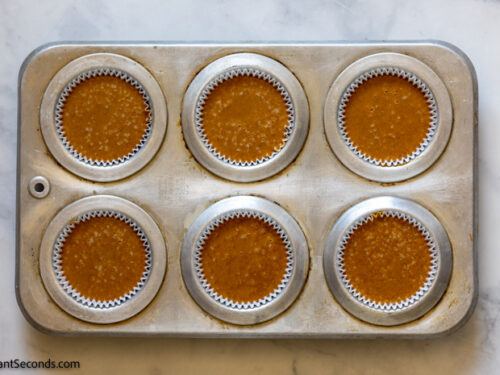 How to make pumpkin spice pie cupcakes , pouring the cupcake mixture in the muffin tins