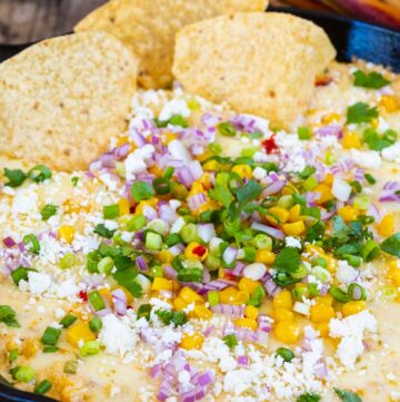 mexican corn dip with toppings and tortilla chips