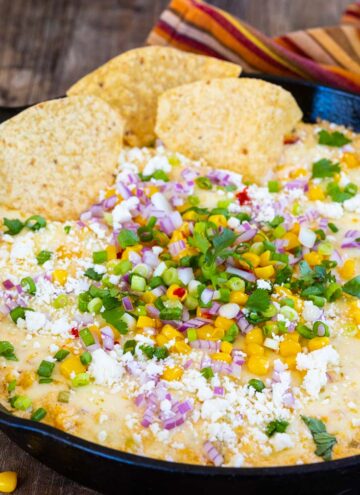 mexican corn dip with toppings and tortilla chips
