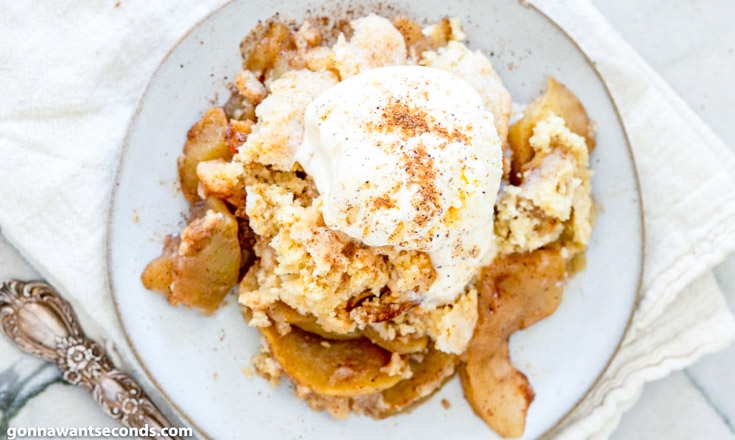 apple cobbler recipe topped with vanilla ice cream, on a plate