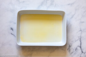 how to make parmesan potatoes , pour melted butter in baking pan