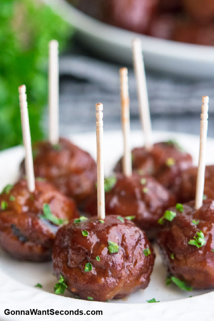 Grape Jelly Meatballs with toothpicks, sprinkled with chopped parsley
