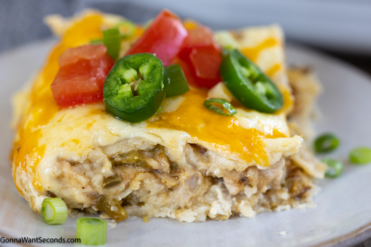 a slice of new mexico green chile chicken enchiladas with jalapeno on top