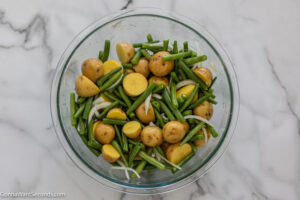 how to make sausage green bean and potato casserole , toss the green beans and potato