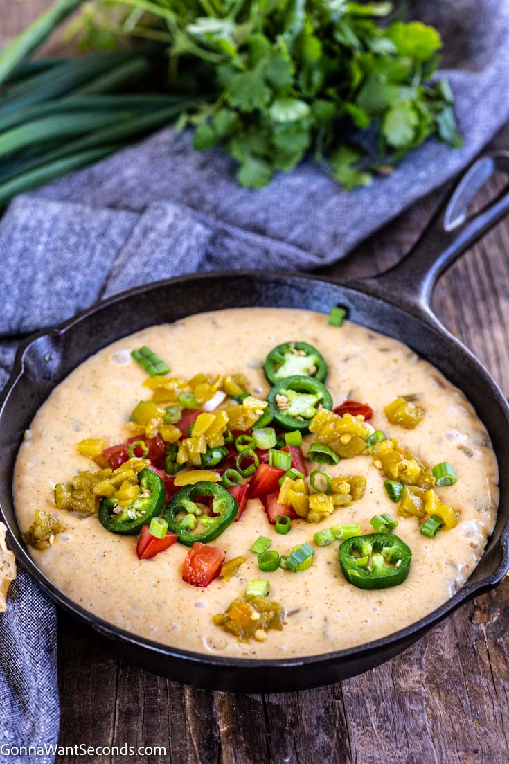 white Queso dip topped with jalapenos dip on a cast iron skillet
