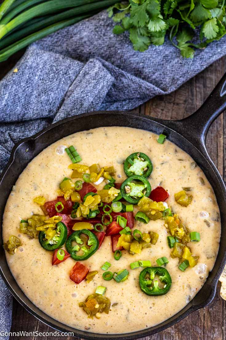 queso blanco dip topped with jalapenos dip on a cast iron skillet