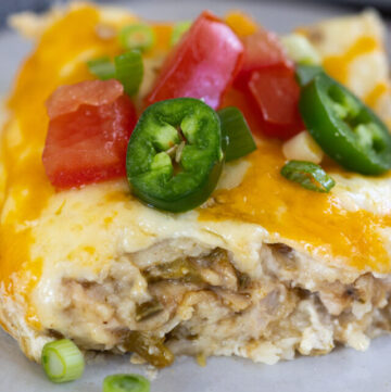 a slice of Green chicken enchilada casserole with jalapeno on top