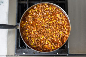 how to make bisquick impossible taco bake step 3, Stir in taco seasoning, cumin, oragano, tomato sauce, salsa, and corn