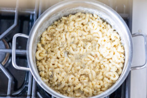 How to make green chile mac and cheese, combined cooked pasta and cheese sauce.