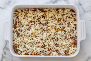Step 6 how to make mexican casserole, Sprinkle with half the cheese.