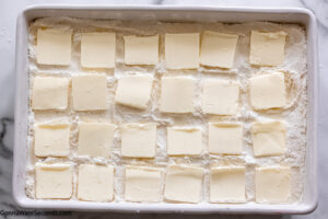 step 3 how to make strawberry dump cake with yellow cake mix, arrange the butter slices on top of the cake mix