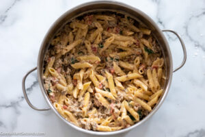 Step 5 How to make creamy tuscan sausage pasta, stir in cooked pasta