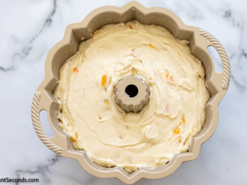 Step 9 how to make peach cobbler cake recipe, Pour batter into the prepared bundt pan.