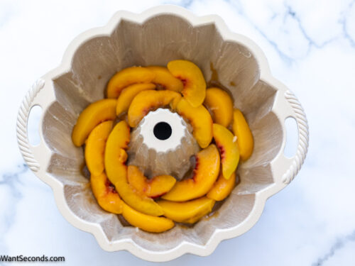 Step 2 how to make peach bundt cake, Arrange peach slices on top of the brown sugar mixture.