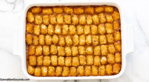 Step 6 how to make mexican tater tot casserole with black beans, spread the meat mixture and layer tater tots on top
