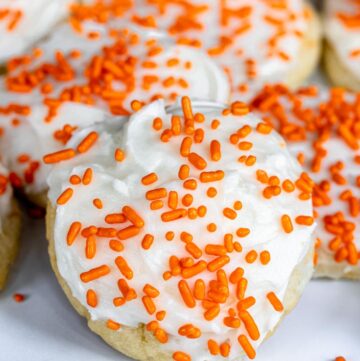 orange cookies with frosting and sprinkles