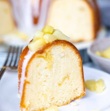 a slice of pineapple pound cake with glaze and pineapple tidbits on top