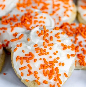 orange cookies with frosting and sprinkles