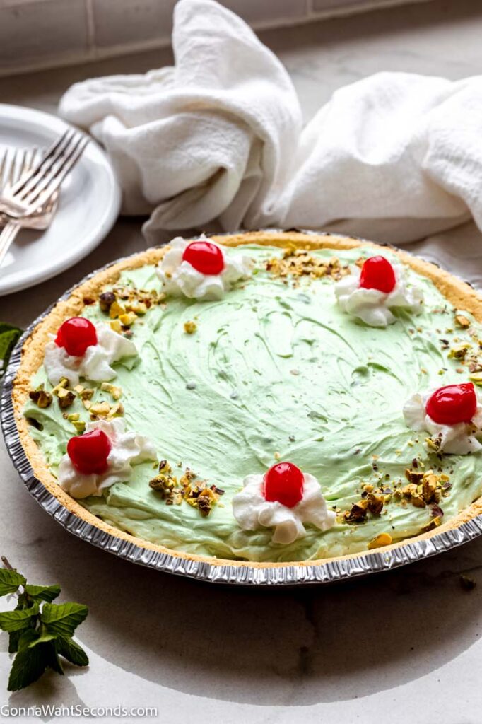 whole pistachio pie topped with cherries