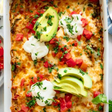 chicken fajita casserole topped with sliced avocados, sour cream and tomatoes
