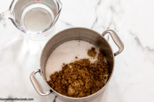 Step 2 how to make simple brine for turkey, place salt and brown sugar in a sauce pan, add water and boil.