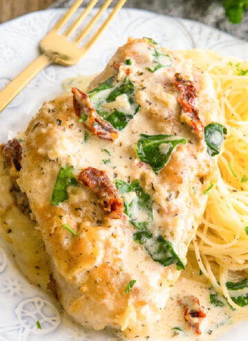 creamy Tuscan garlic chicken with pasta on the side, on a plate