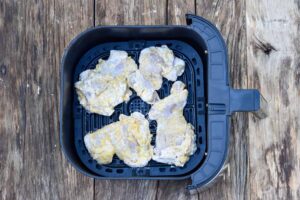 Step 8 how to make air fryer chicken, Mist the chicken with vegetable oil and cook the chicken in the air fryer.